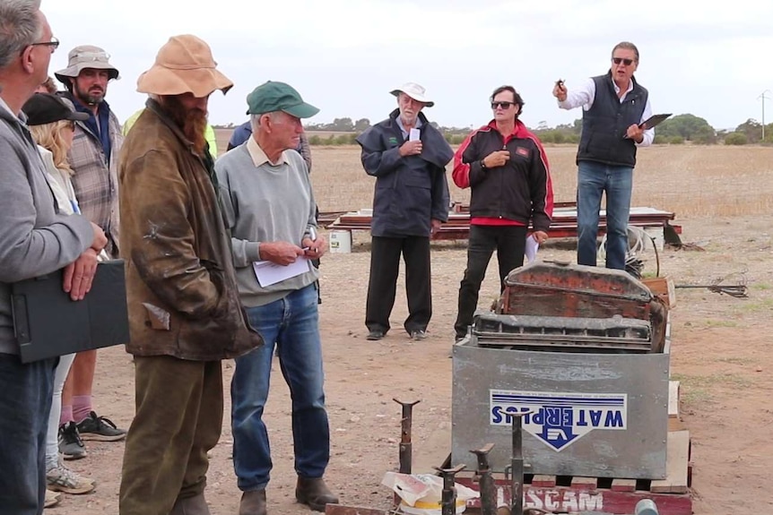 People on left and right, centre is auctioneer with hammer raised