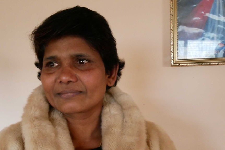 A Sri Lankan woman wearing a jacket in a house