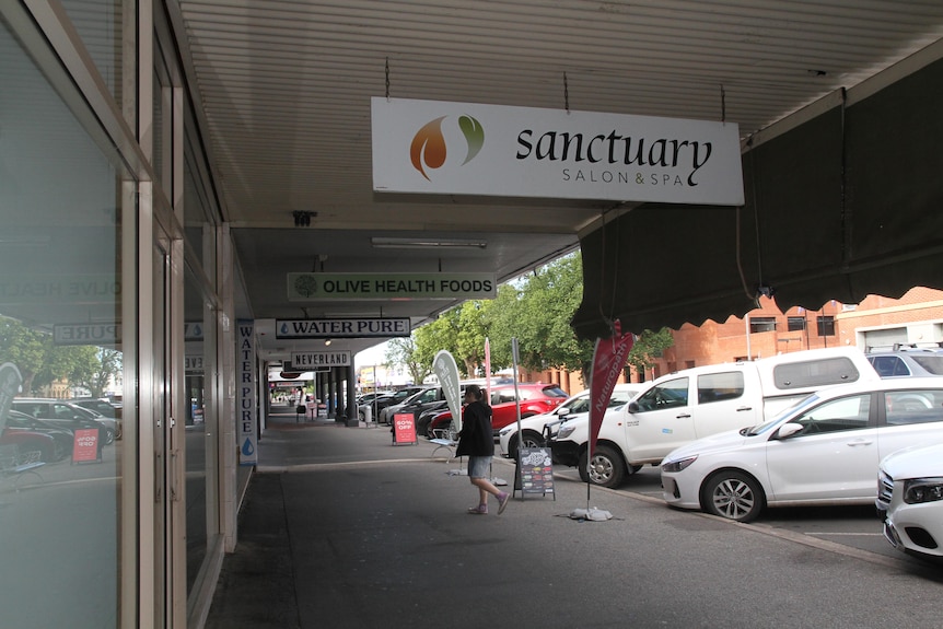 An image of an Albury shopfront with a woman walking down the street in the foreground.