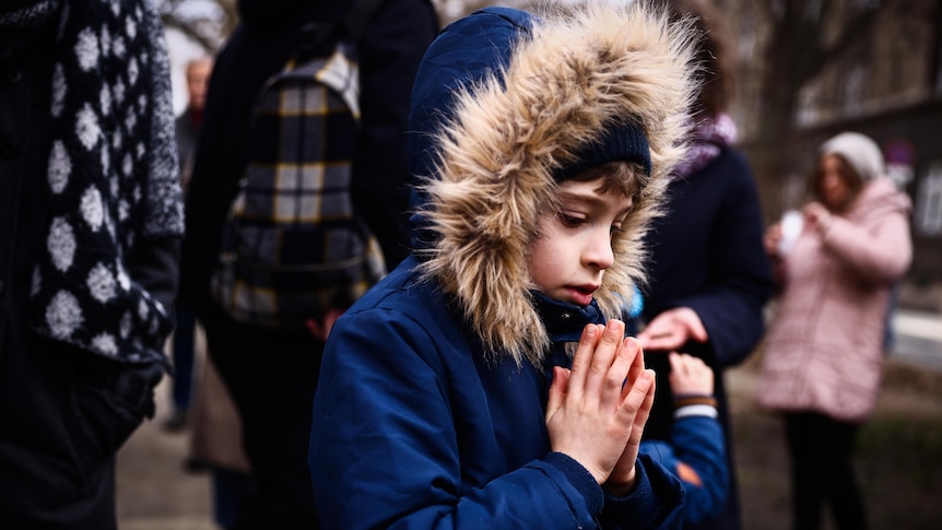 A young boy prays.