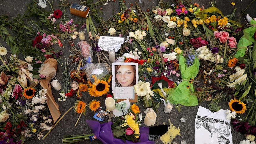 Flowers, candle and cards left on the road, encircle a photo of Heather Heyer.
