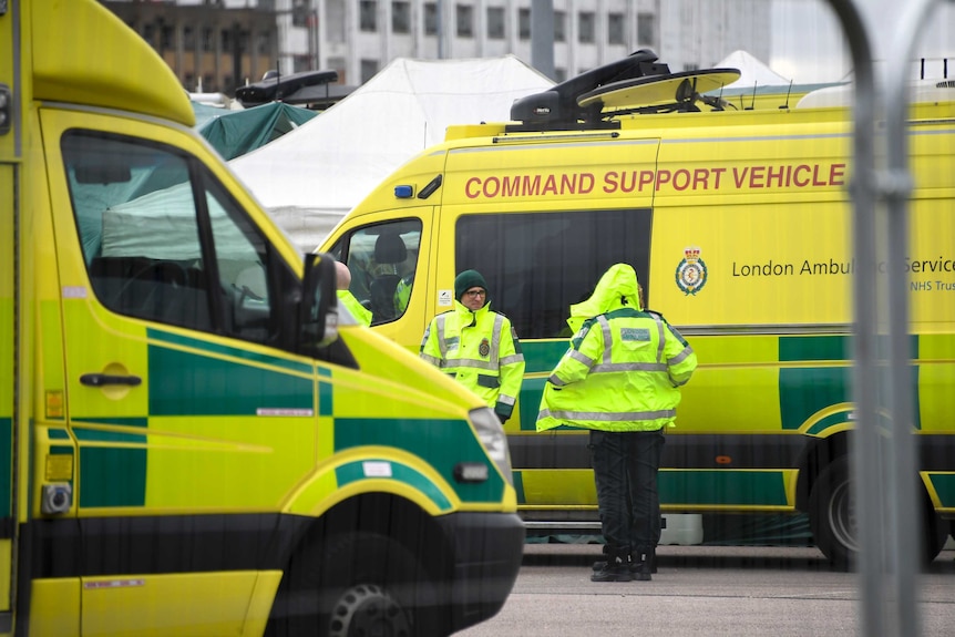 Bright yellow ambulances sit outside a London hospital.