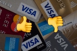 A pile of credit cards with a thumbs up and thumbs down in front of them.