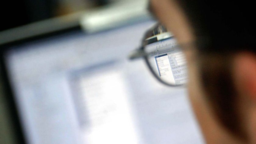 An office worker looks at their computer screen