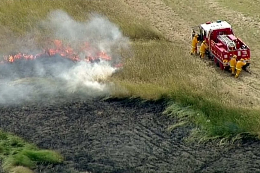 An aerial shot of firefighters battling a grassfire.