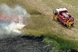 An aerial shot of firefighters battling a grassfire.