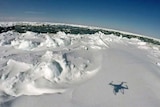 A drone casts a shadow while flying over sea ice in Antarctica.