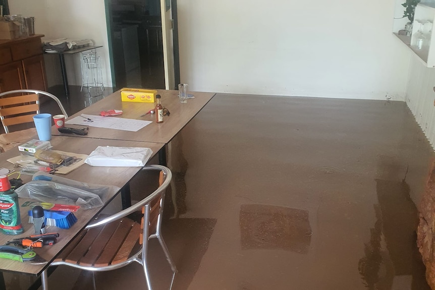 Flooded floor with restaurant kitchen and tables.