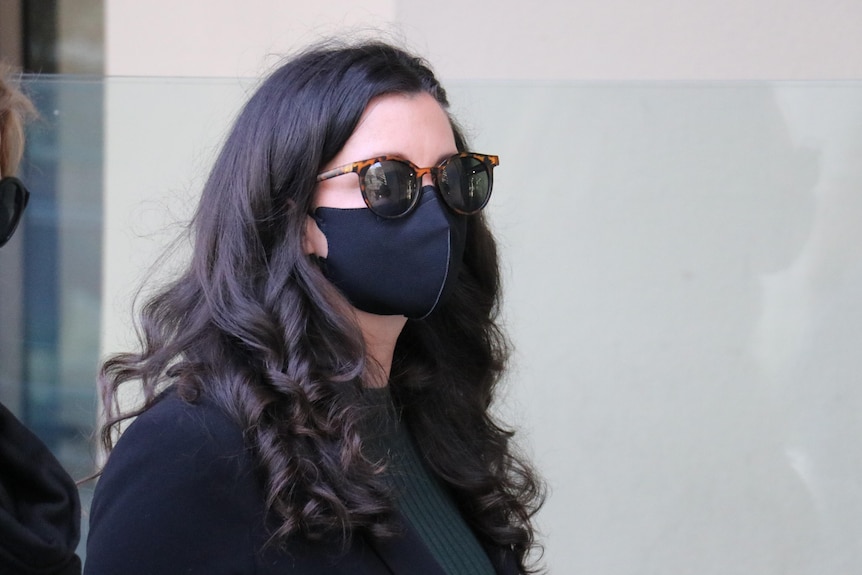 Nurse Jacqueline Taylor outside wearing a black COVID mask outside the coroner's court.