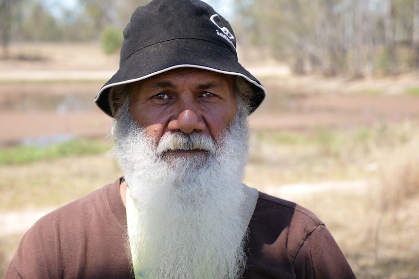 Milton Lawton wearing a hat, tight shot of his shoulders and head, looking straight at the camera, straight-face.