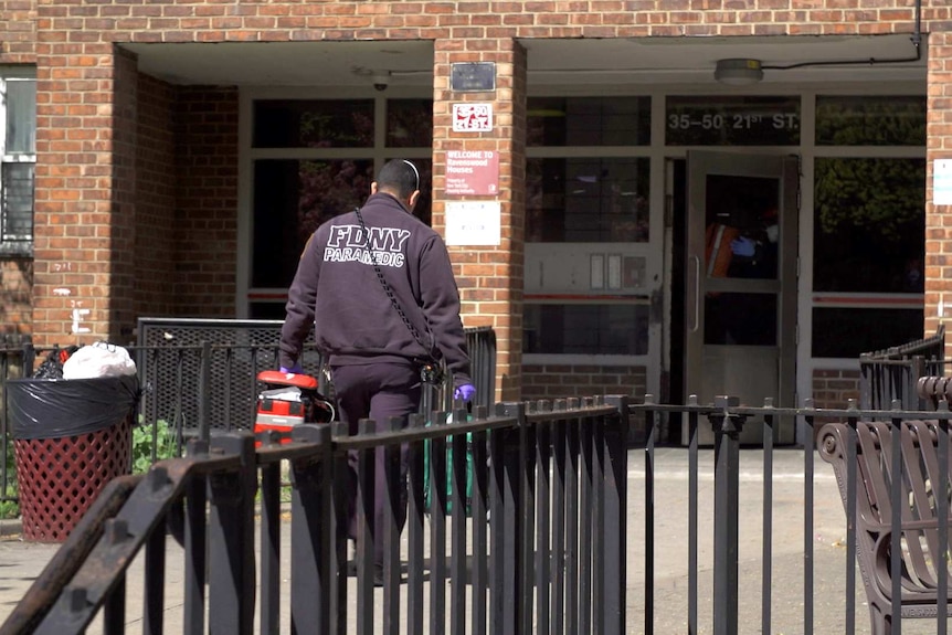 A paramedic enters a building.