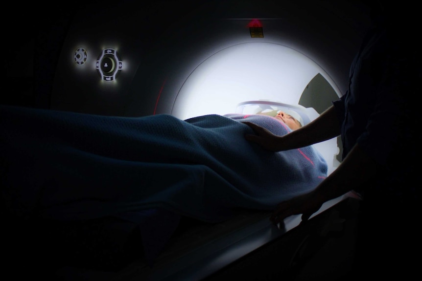 A person lies in a CT machine