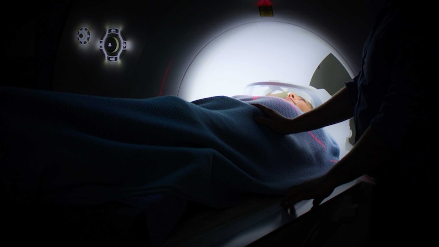A person lies in a CT machine