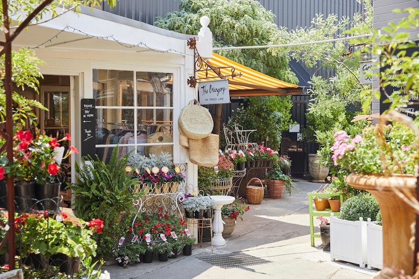 A market stall at Dirty Jane's in Bowral, surrounded by bright flowers.