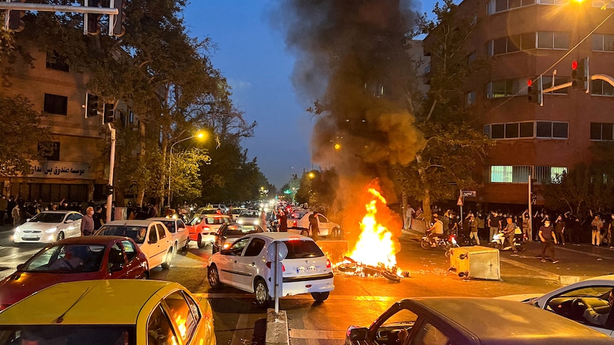 A police motorcycle burns during a protest over the death of Mahsa Amini.