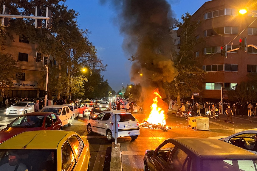 A police motorcycle burns during a protest over the death of Mahsa Amini.