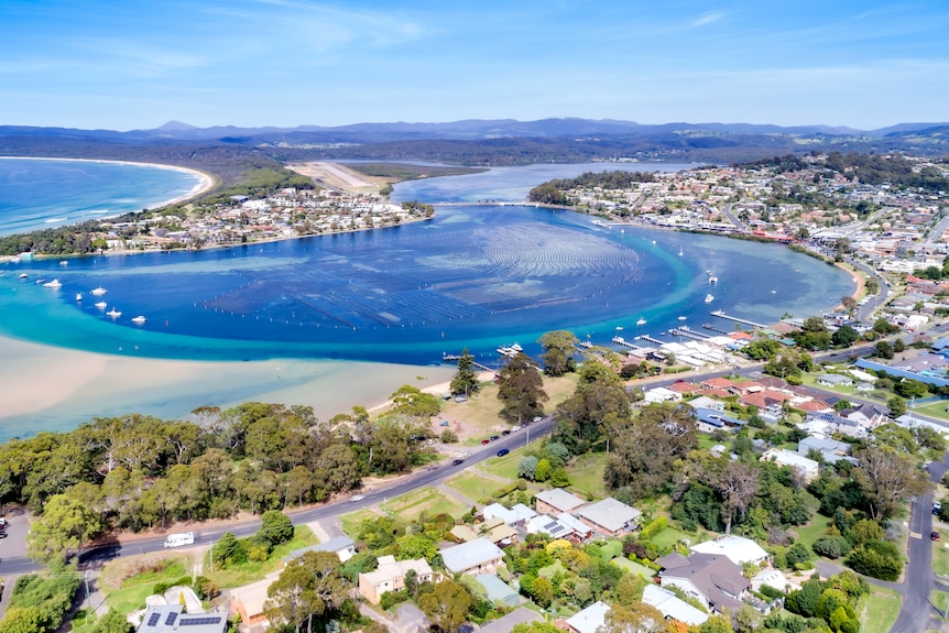 un tir de drone de merimbula comprenant des maisons et un lac près de l'océan