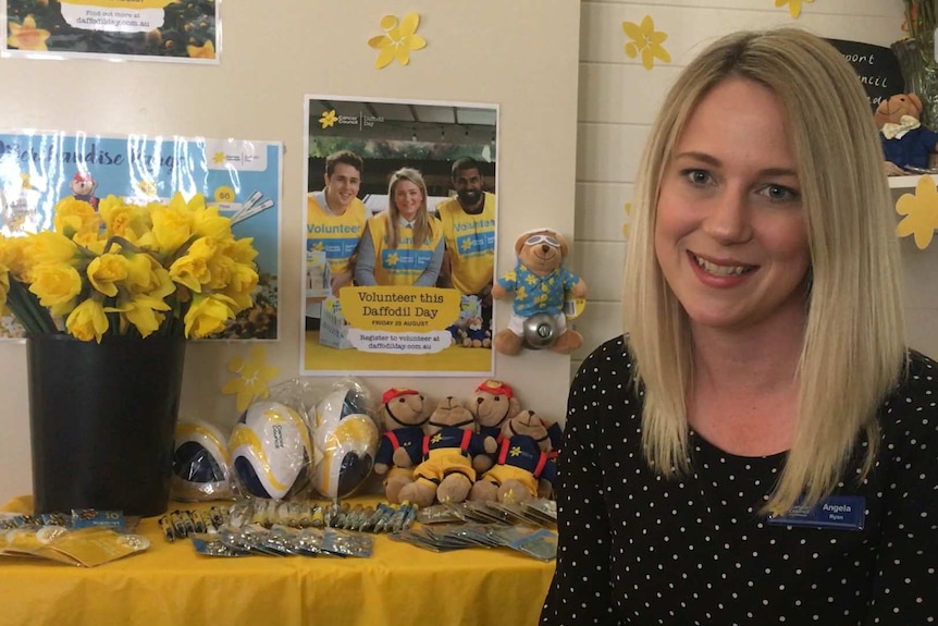 Angela Ryan from the Queensland Cancer Council with daffodils and fundraising merchandise
