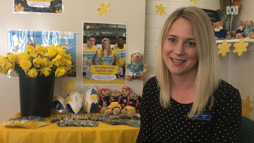 Angela Ryan from the Queensland Cancer Council with daffodils and fundraising merchandise