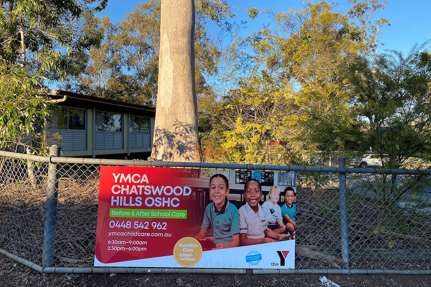 Sign on fence for YMCA Chatswood Hills OSHC at Chatswood State Primary School at Springwood, south of Brisbane.