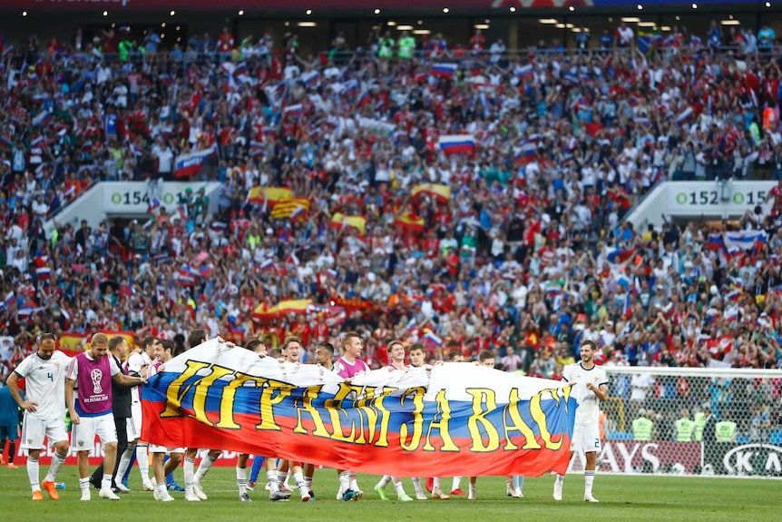 Russia players hold up banner thanking crowd after beating Spain