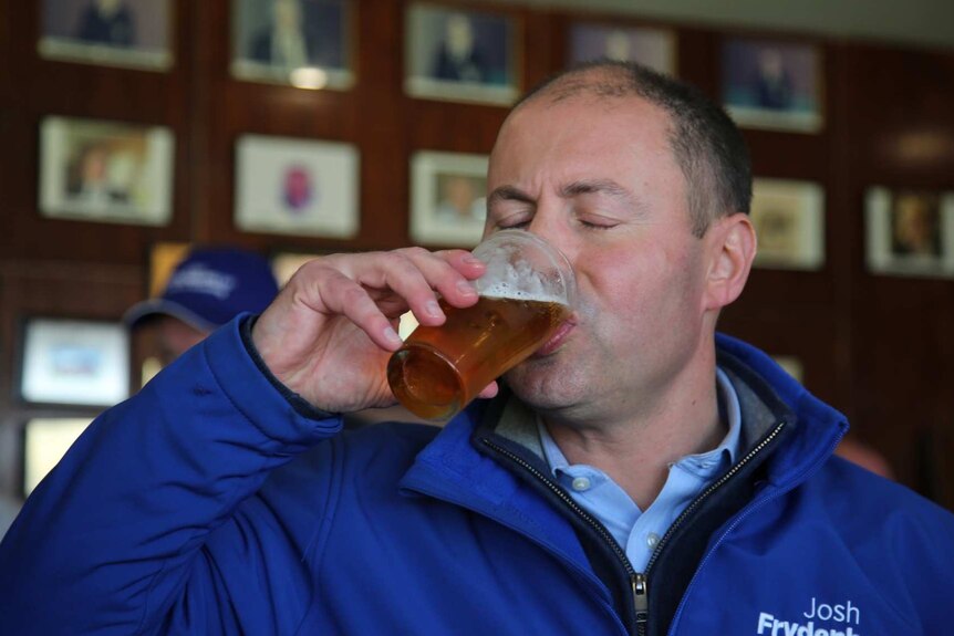 Josh Frydenberg closes his eyes as he drinks a pot of beer.
