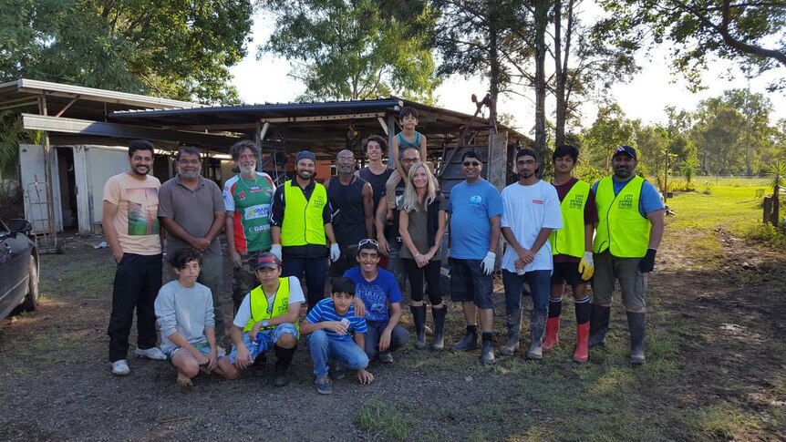 Volunteers pose outside a house in North MacLean.