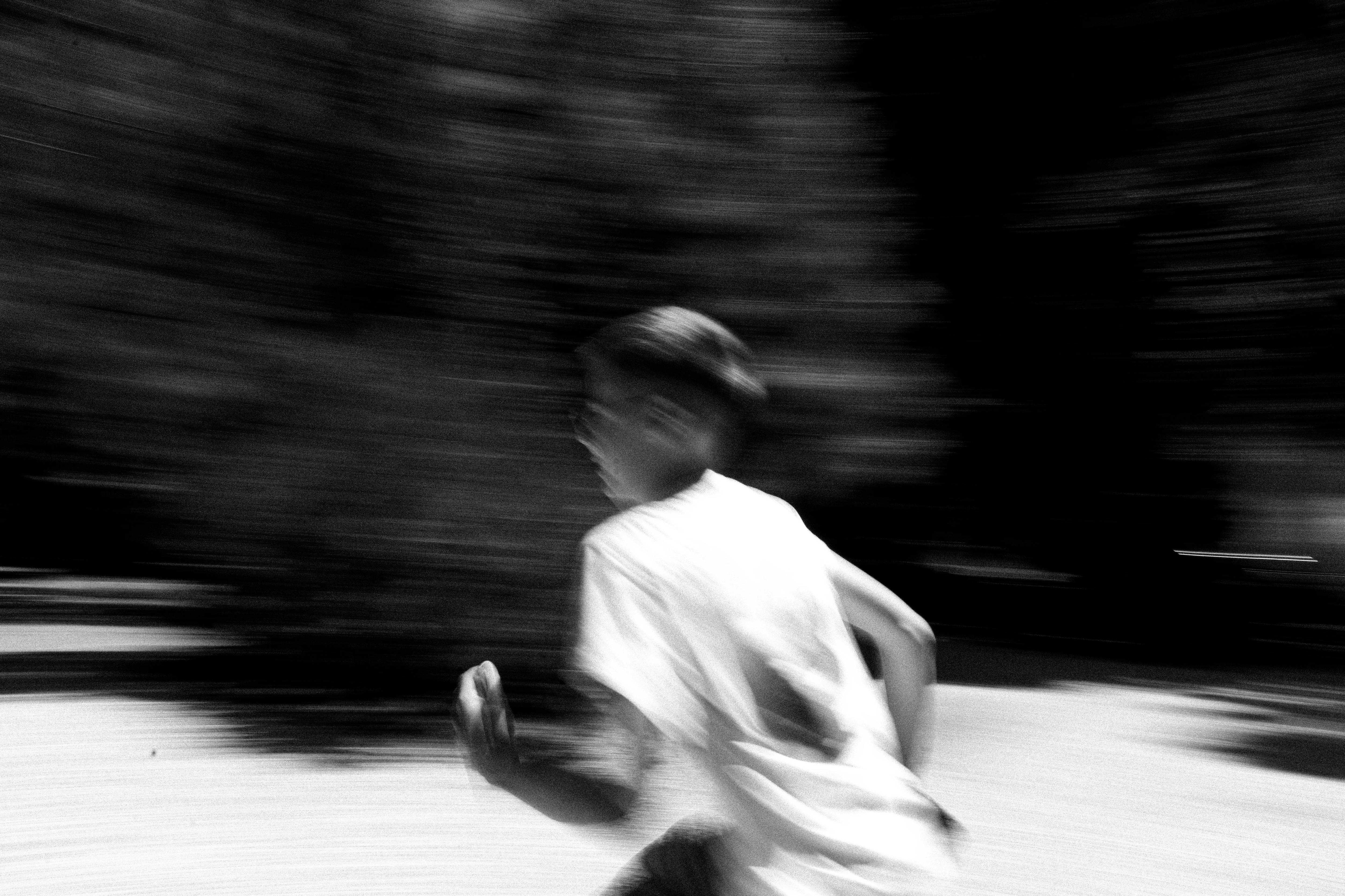 blurry black and white image of person running 