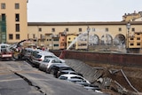 Cars are partially submerged in the embankment near the Ponte Vecchio bridge.