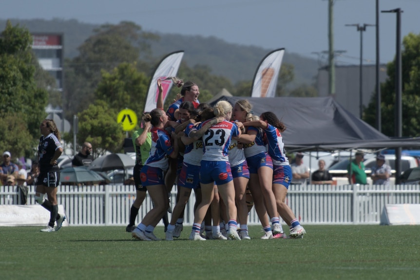 a womens football team celebrate winning a grand final at the Koori Knockout