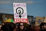 A demonstrator holds a poster calling for more liberal abortion laws.