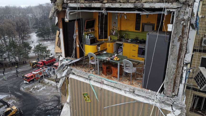 A view shows a yellow kitchen inside an apartment block heavily damaged by a Russian missile strike