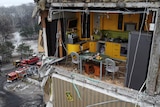 A view shows a yellow kitchen inside an apartment block heavily damaged by a Russian missile strike