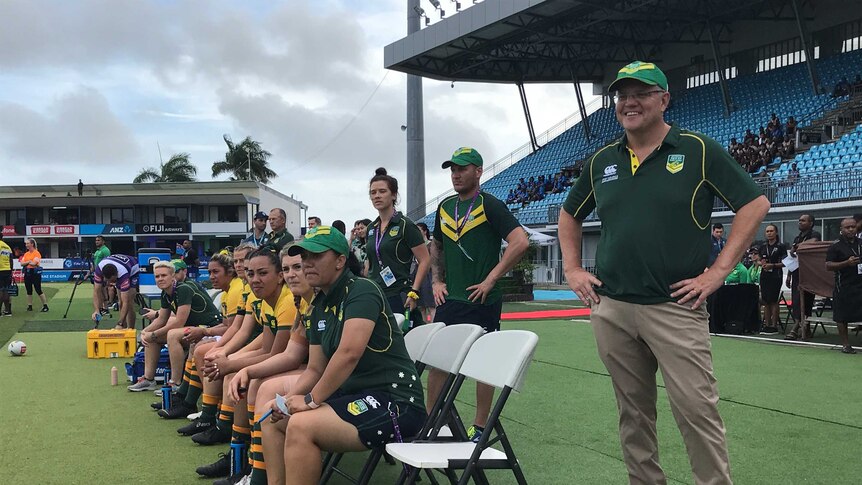 Scott Morrison at ANZ National Stadium in Suva. He is standing on the field with some Australian Rugby League players.