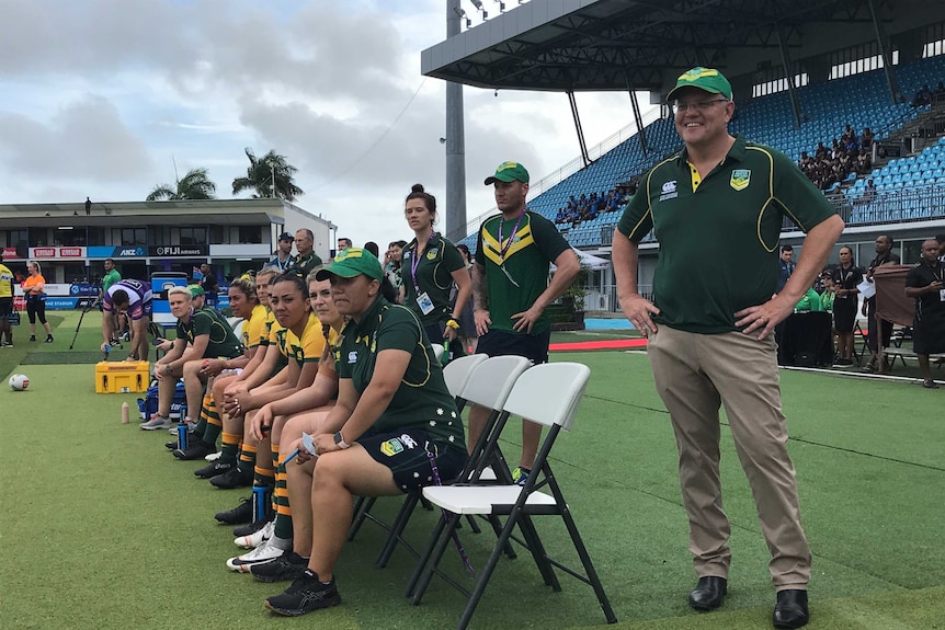 Scott Morrison at ANZ National Stadium in Suva. He is standing on the field with some Australian Rugby League players.