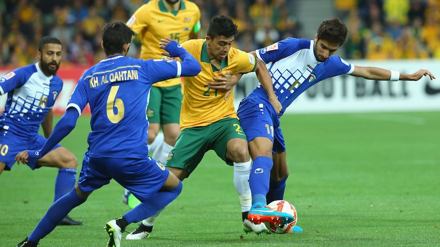 Australia's Massimo Luongo and Kuwait's Fahed Al Ebrahim contest the ball in their Asian Cup match.