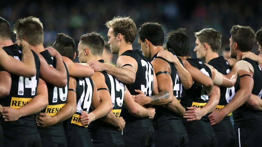 Moving tribute ... Port Adelaide observe a moment's silence in memory of the late Phil Walsh