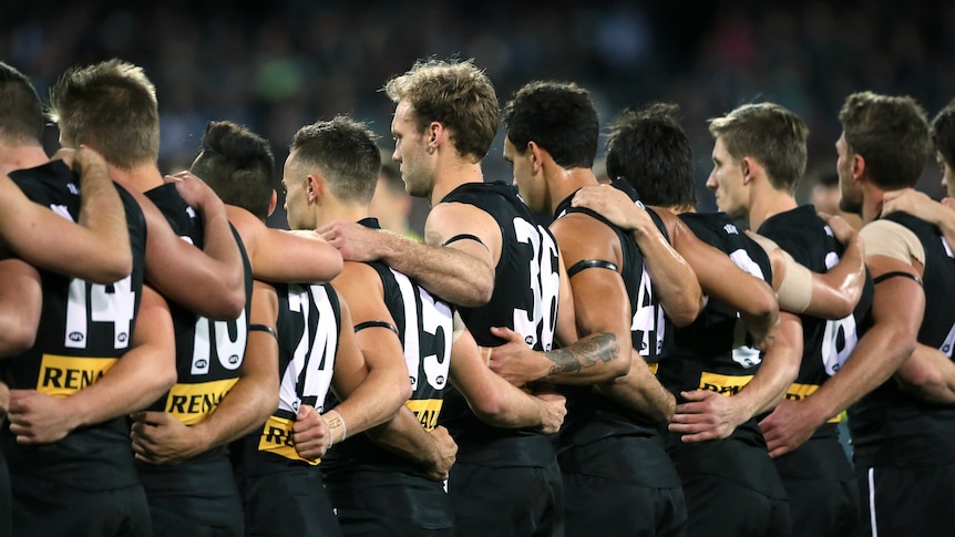 Moving tribute ... Port Adelaide observe a moment's silence in memory of the late Phil Walsh
