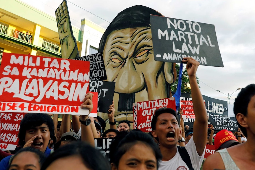 Protesters chant slogans as Philippine President Rodrigo Duterte delivers his State of the Nation address.
