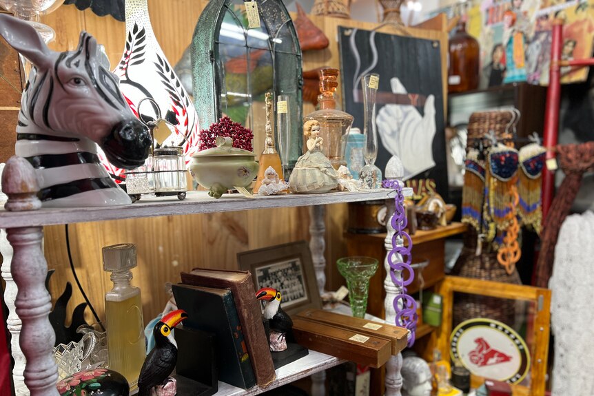 A display shelf inside an antique market showcases a variety of collectables.
