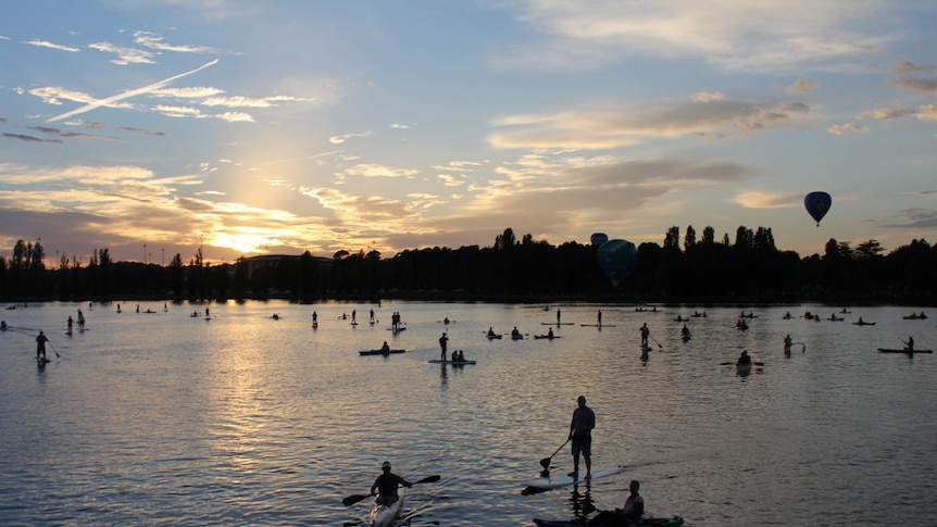 Stand up paddle boarders and Kayakers on lake Burley Griffin.