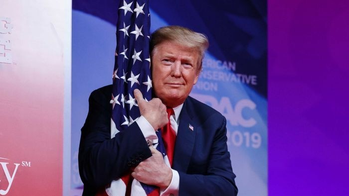 President Donald Trump hugs a US flag