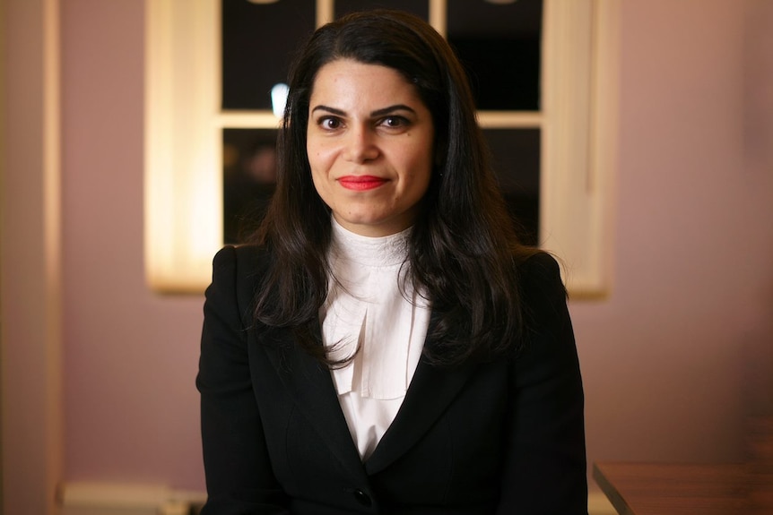 A woman wearing a smart suit, smiling at the camera.