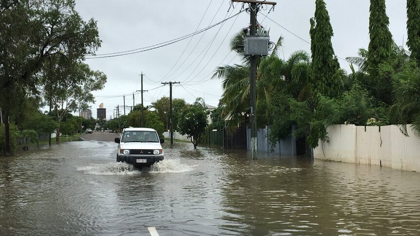 A car drives through receding water in Railway Estate in Townsville.