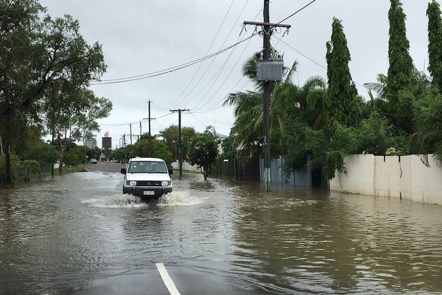 A car drives through receding water in Railway Estate in Townsville.