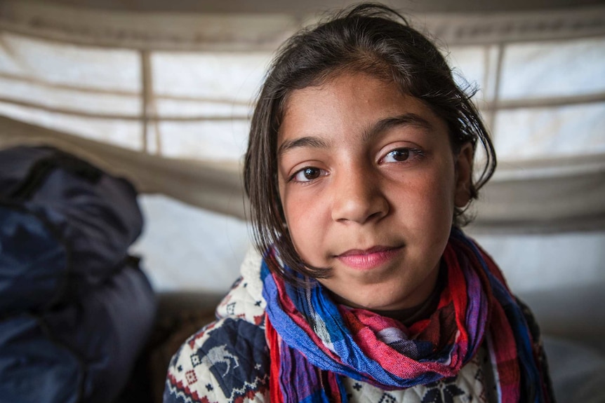 Zainab, 11, in her family's tent in a camp for displaced people in Syria.