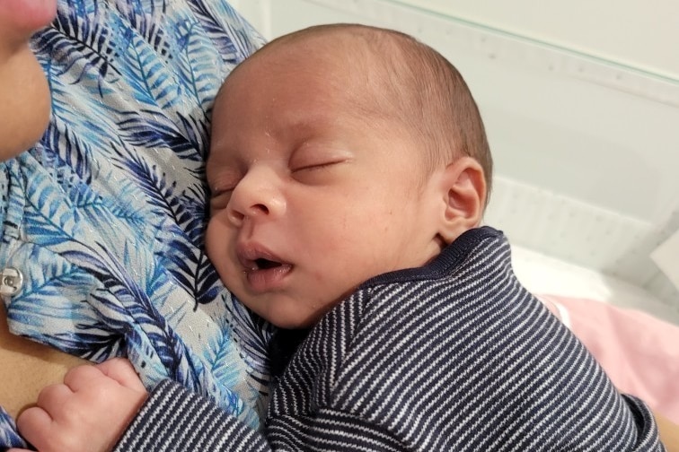 A baby boy lies on his mother's chest.