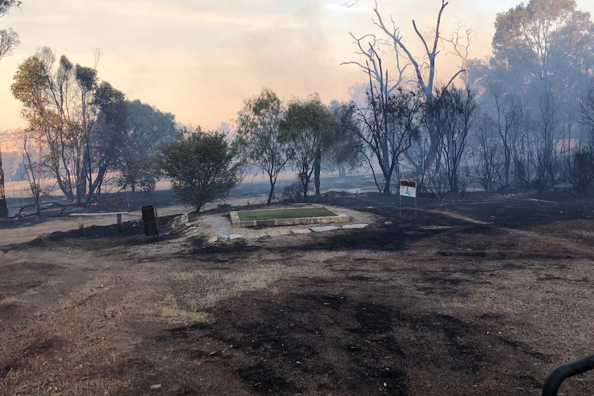 Smoke and fire smoulders on a rural property