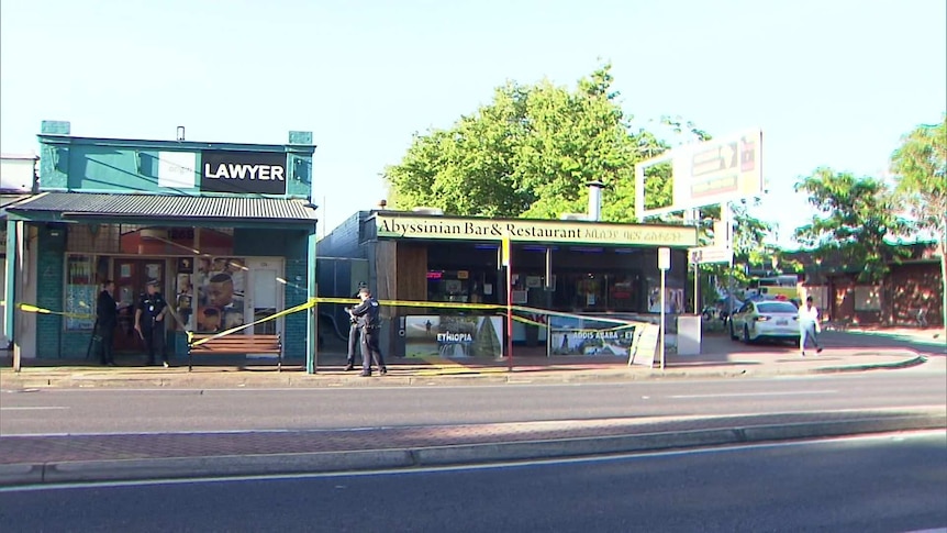 A lawyer's office and a restaurant taped off with crime tape