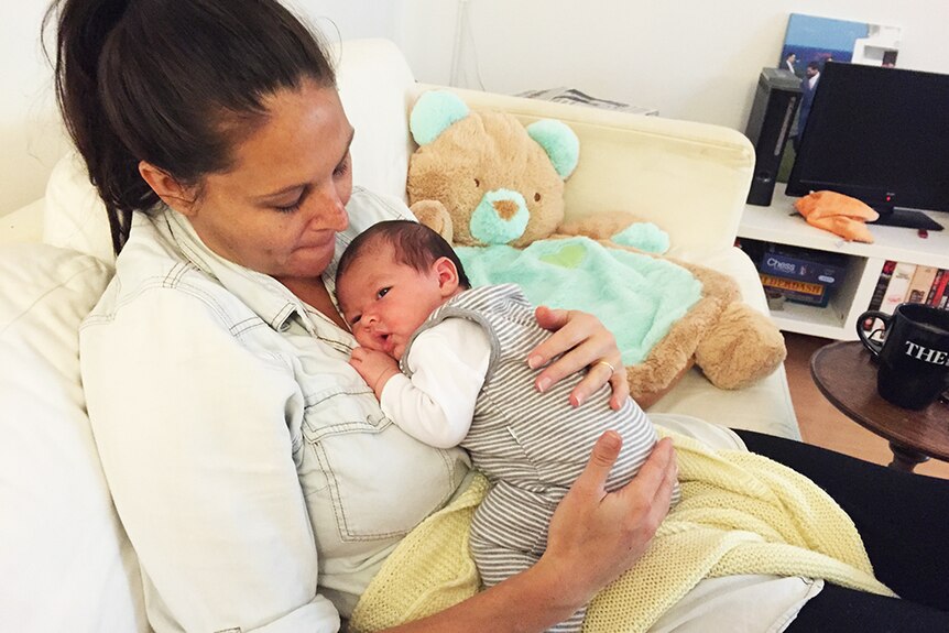 New mum Josie Sargent cradles her weeks-old son at home